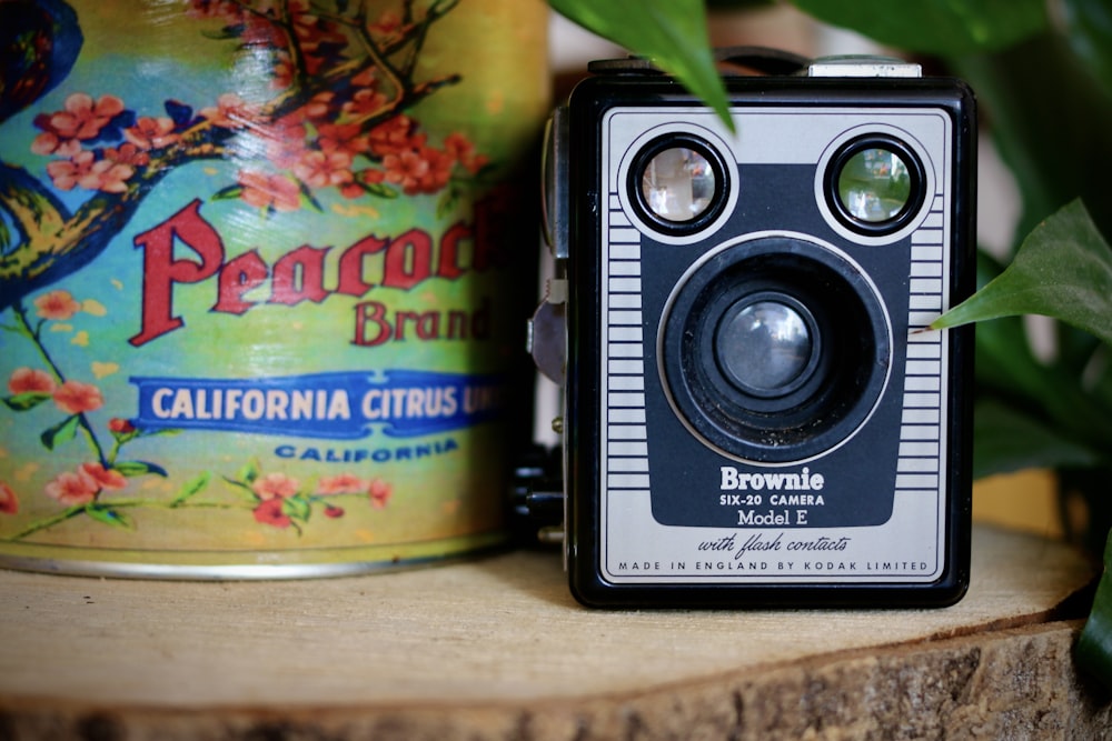 a camera sitting on top of a wooden table next to a can