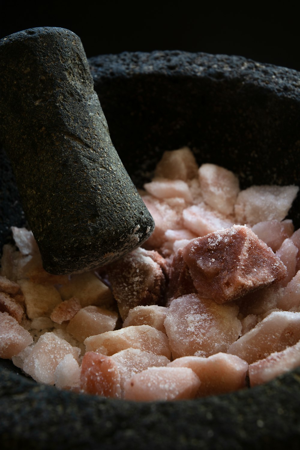 a black bowl filled with food and a piece of meat sticking out of it