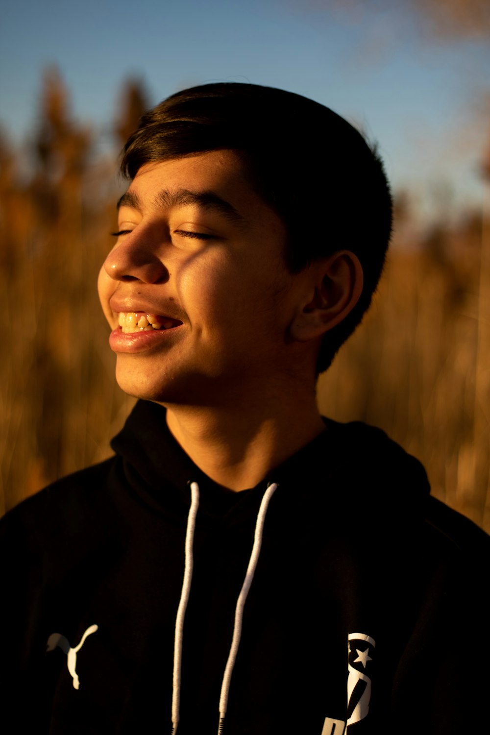 a young man smiling in a field of tall grass