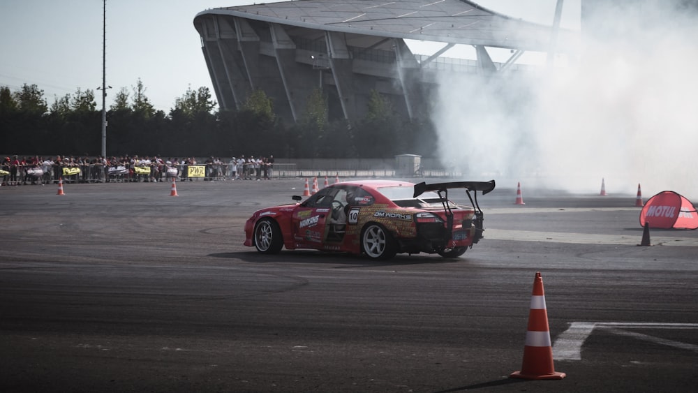 a car driving around a track with smoke coming out of it