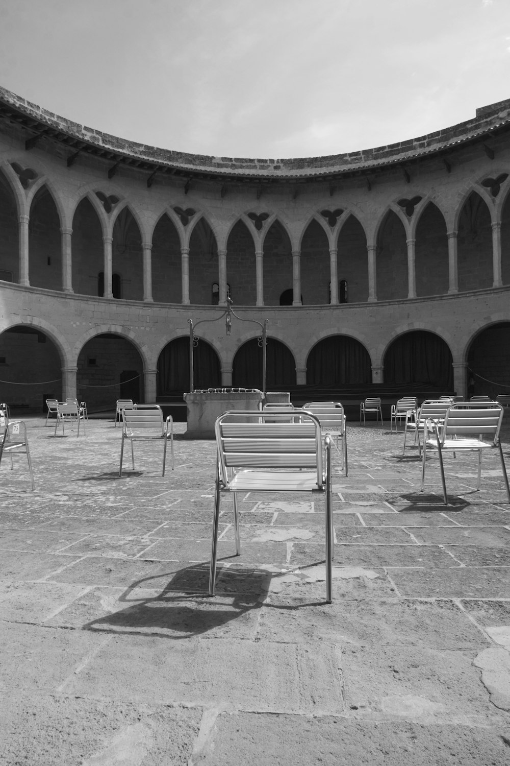 a black and white photo of benches in a courtyard