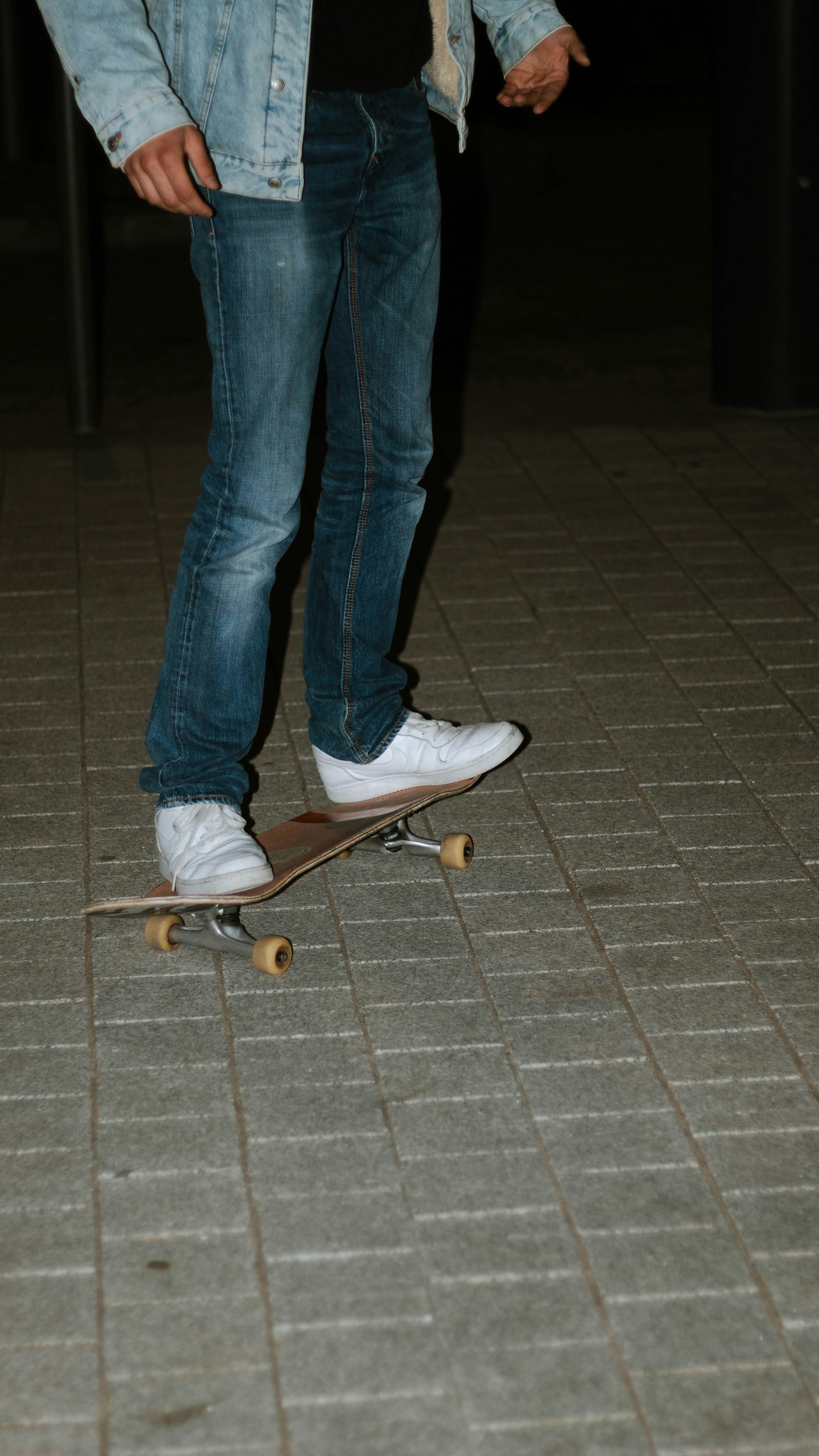 a man standing on a skateboard on a sidewalk