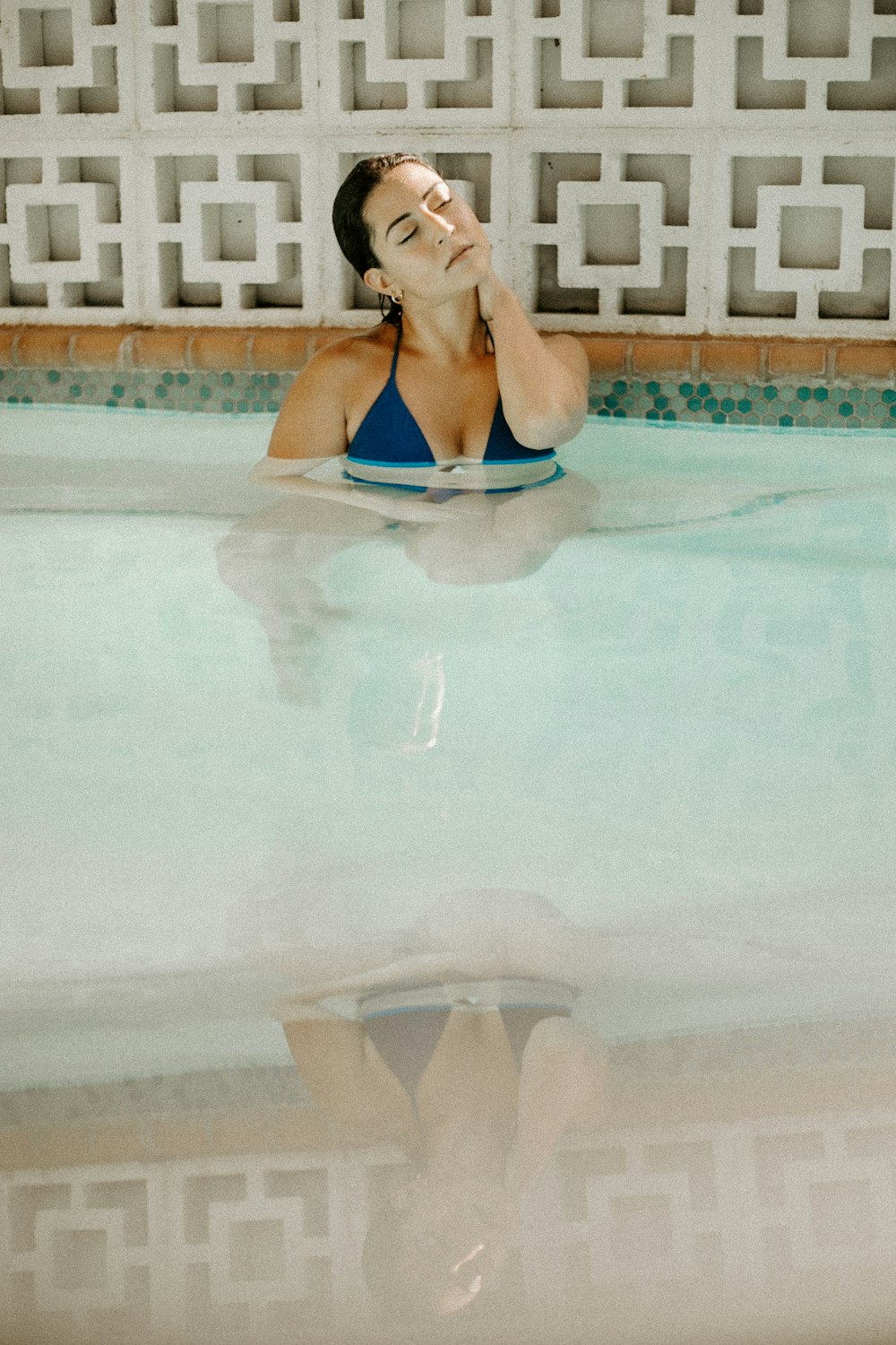 a woman in a blue bikini in a swimming pool