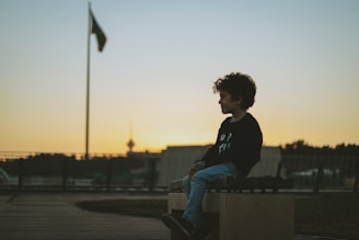 a person sitting on a bench with a flag in the background
