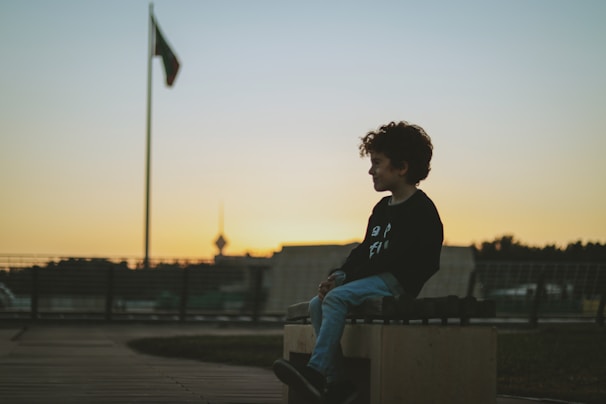 a person sitting on a bench with a flag in the background