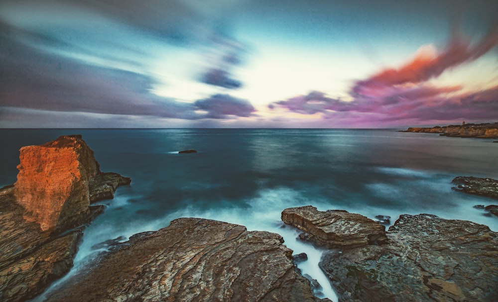 a long exposure photo of a sunset over the ocean