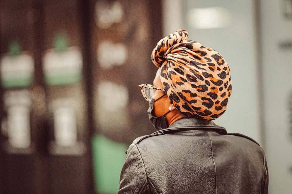 a woman wearing a leopard print scarf and a beanie