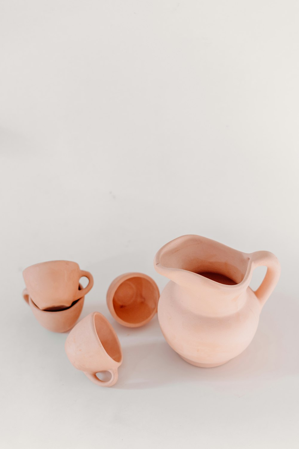 a white table topped with three pink vases