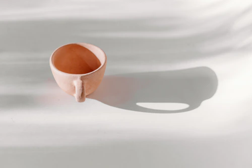 Brown ceramic coffee cup on white table