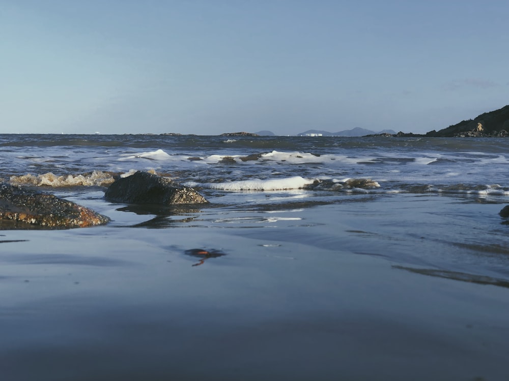 a body of water with rocks in the foreground