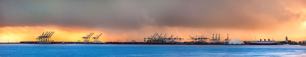 a group of ships in a harbor under a cloudy sky