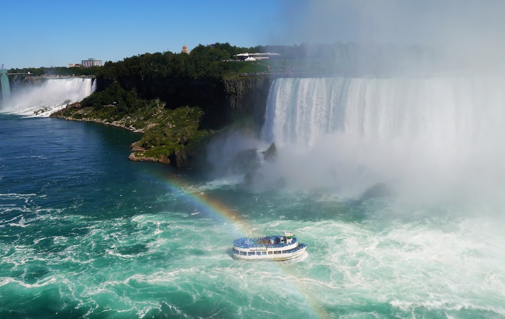 a boat in a body of water near a waterfall