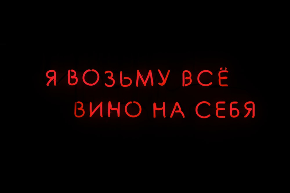 a red neon sign that says russian on a black background