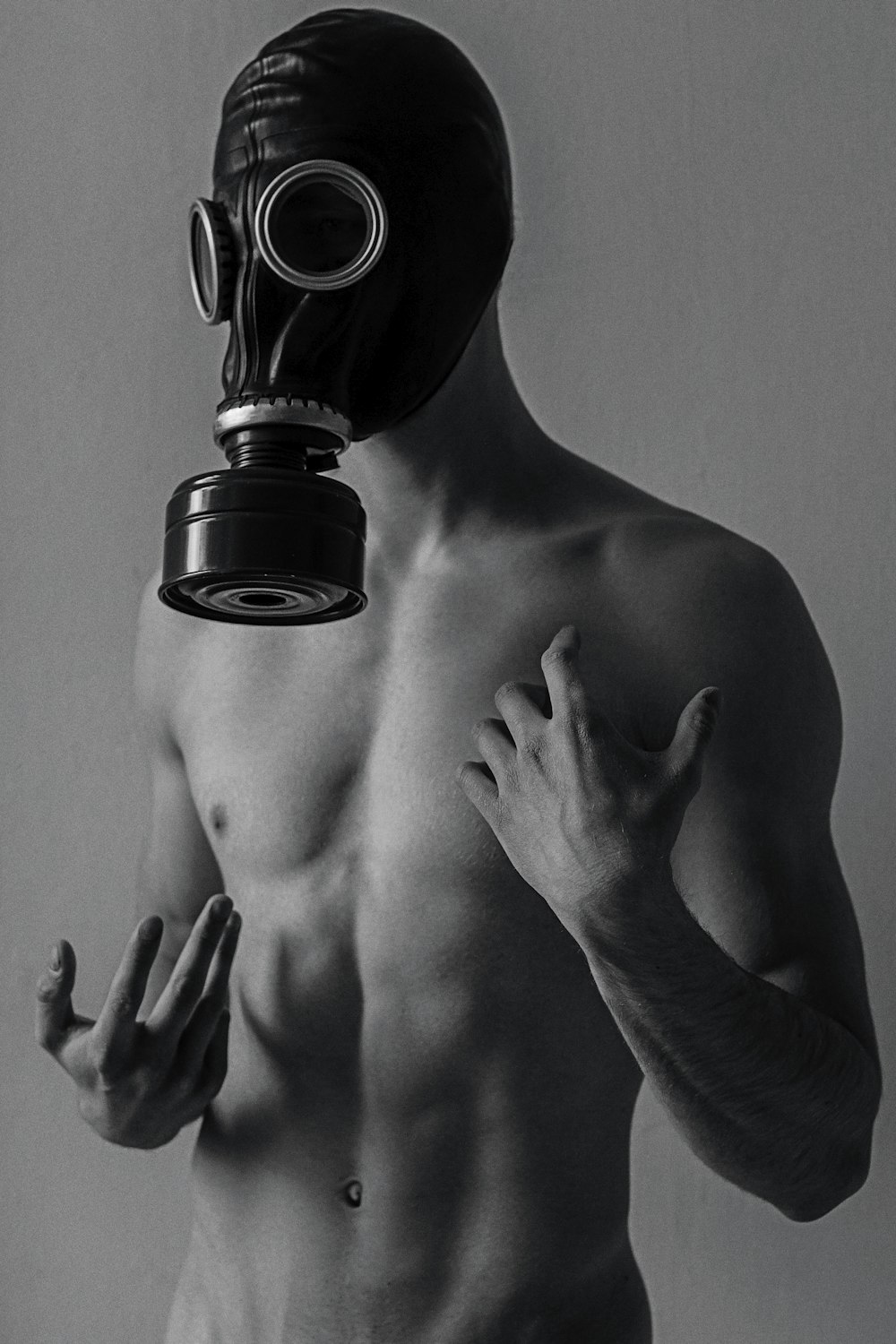 a shirtless man wearing a gas mask