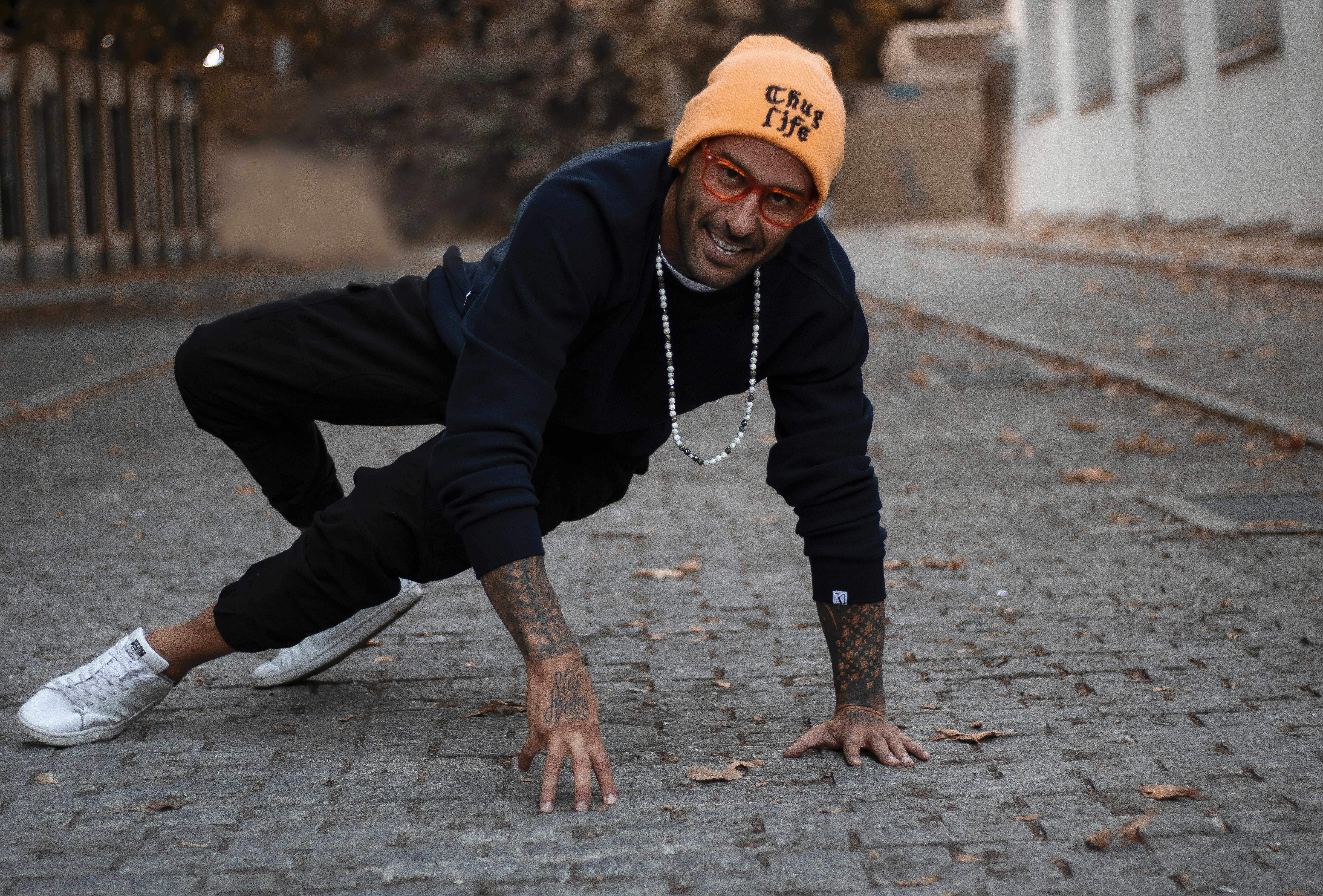 a man wearing a hat and a black sweatshirt is doing a handstand