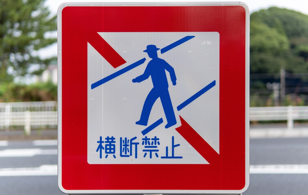 a red and white sign with a man on skis