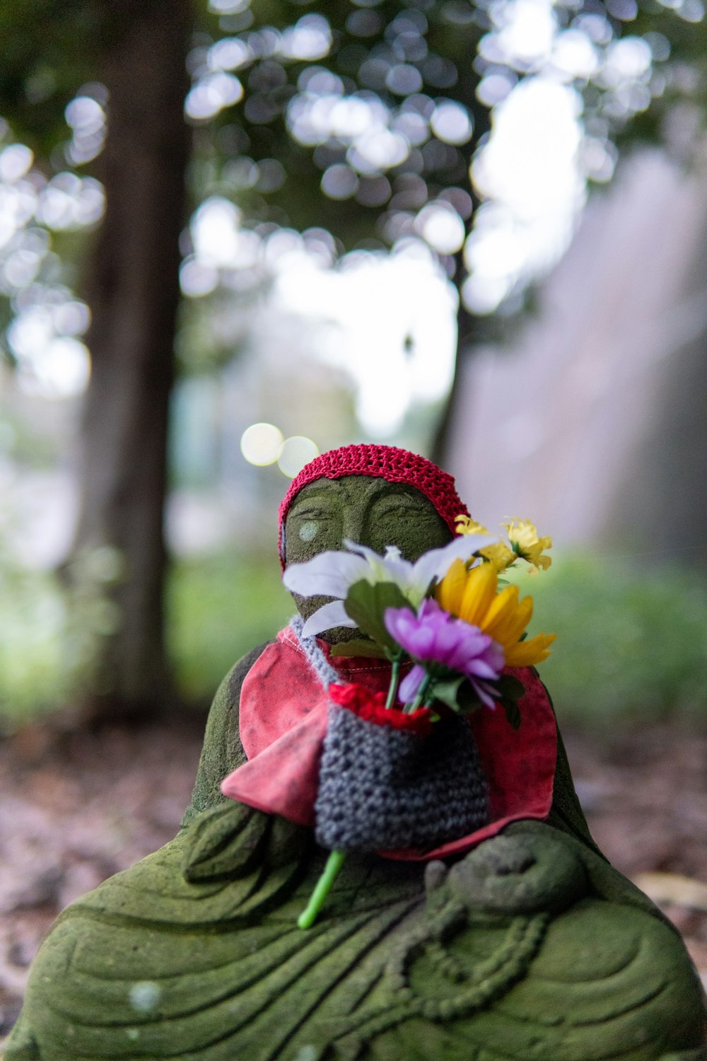 a buddha statue with a bouquet of flowers in its lap