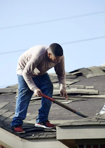 a man with a hammer on top of a roof