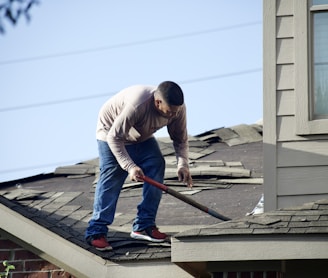 a man with a hammer on top of a roof