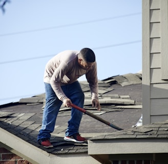 a man with a hammer on top of a roof