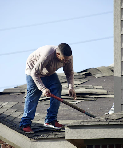 a man with a hammer on top of a roof