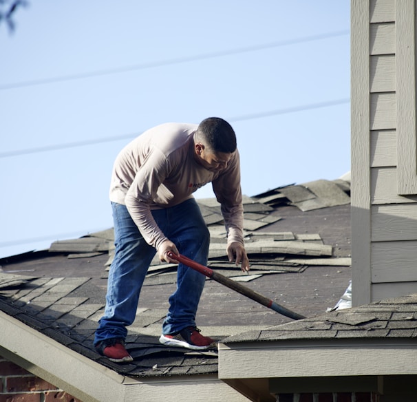 a man with a hammer on top of a roof