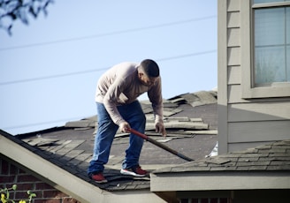 a man with a hammer on top of a roof