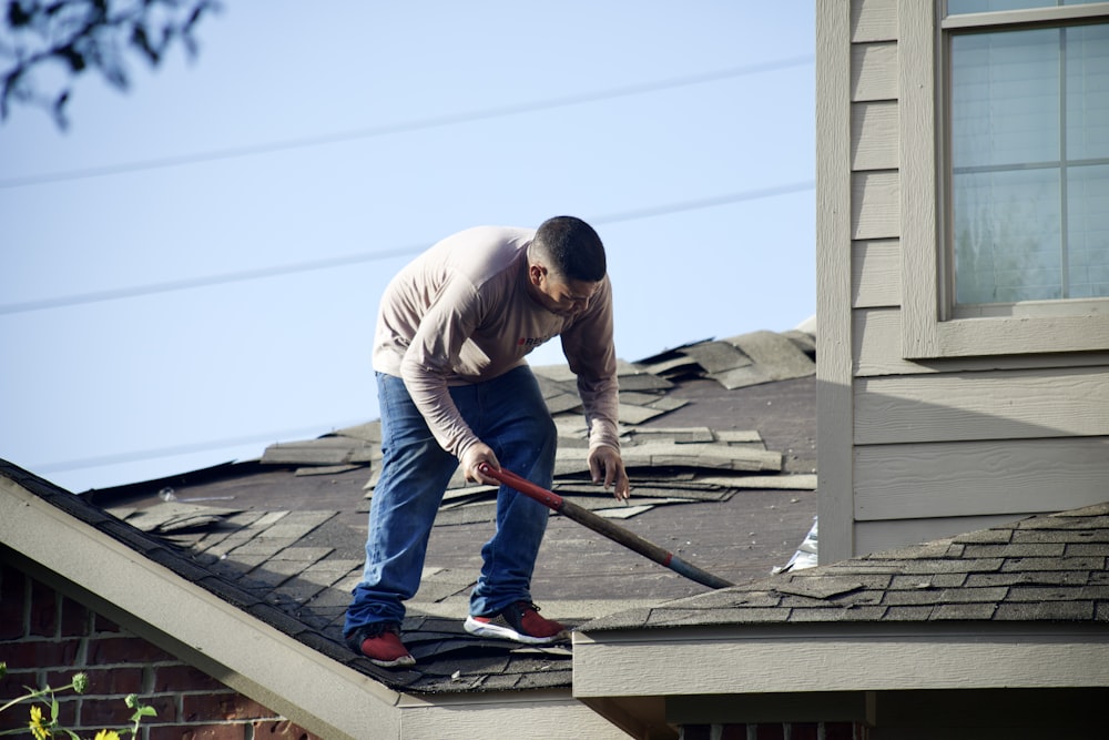 Ein Mann mit einem Hammer auf einem Dach