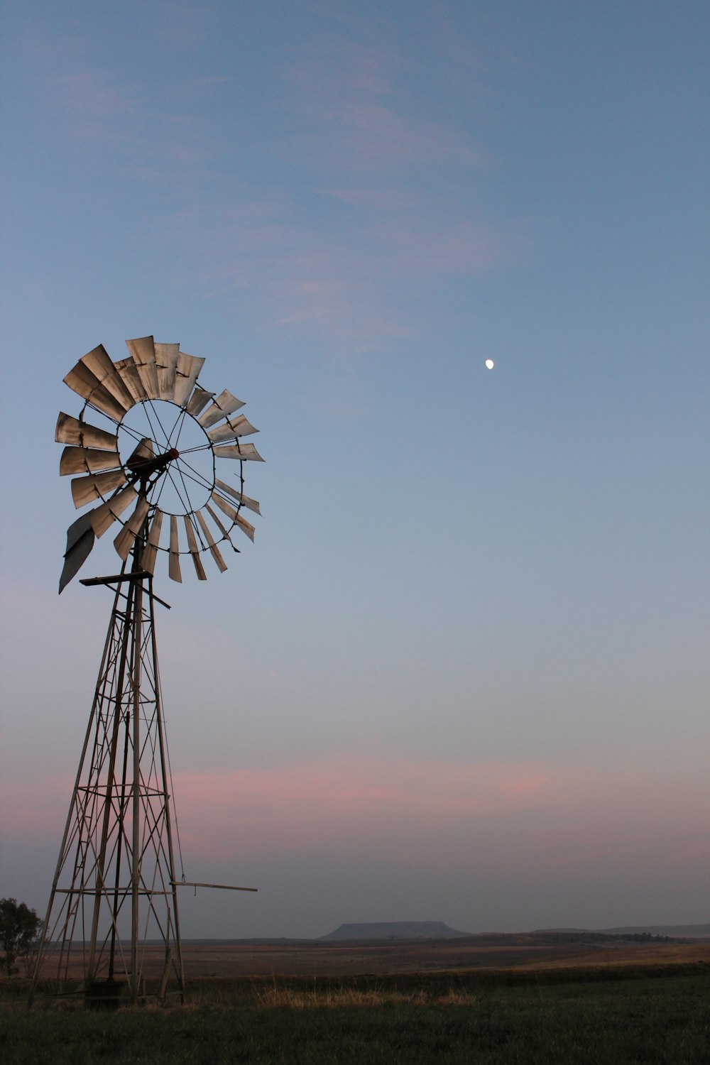 a windmill with a half moon in the background