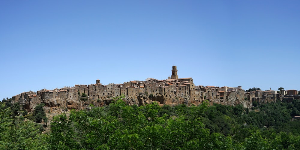 a village on top of a hill surrounded by trees