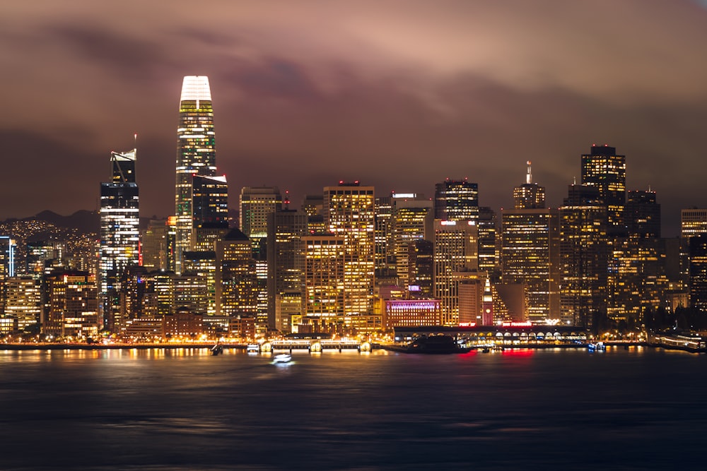 a city skyline at night with a boat in the water