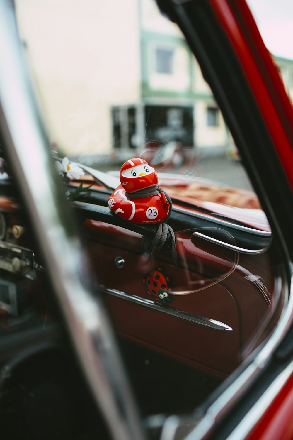a red car with a red helmet on the dashboard
