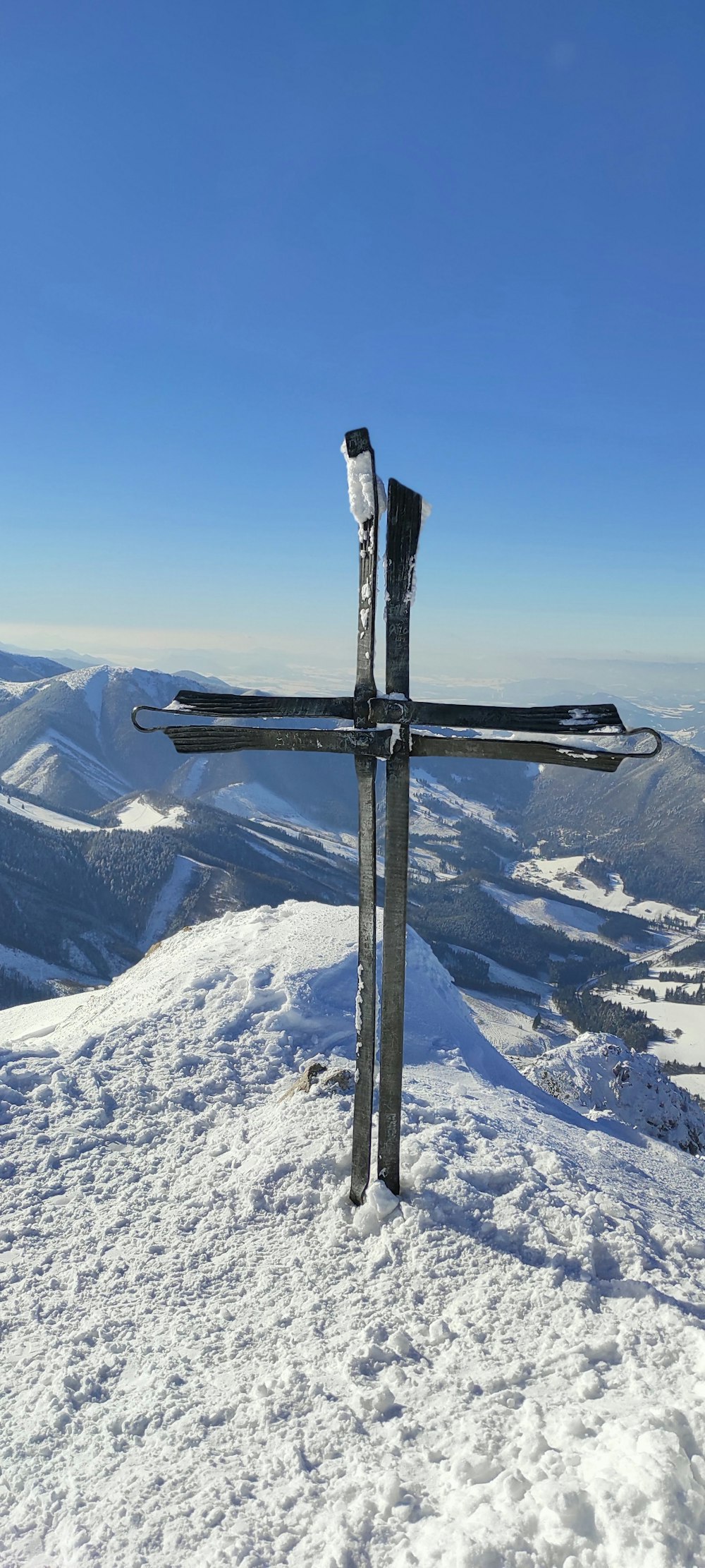 a cross on top of a snow covered mountain