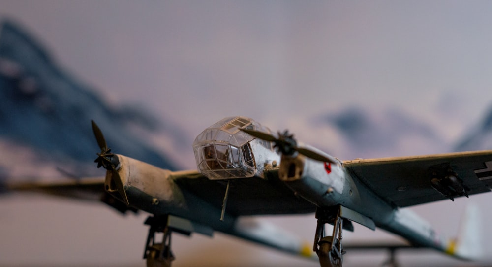Un modelo de un avión de combate con montañas en el fondo