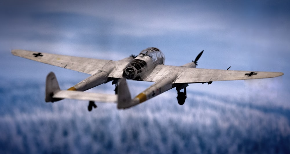 a plane flying in the sky with clouds in the background