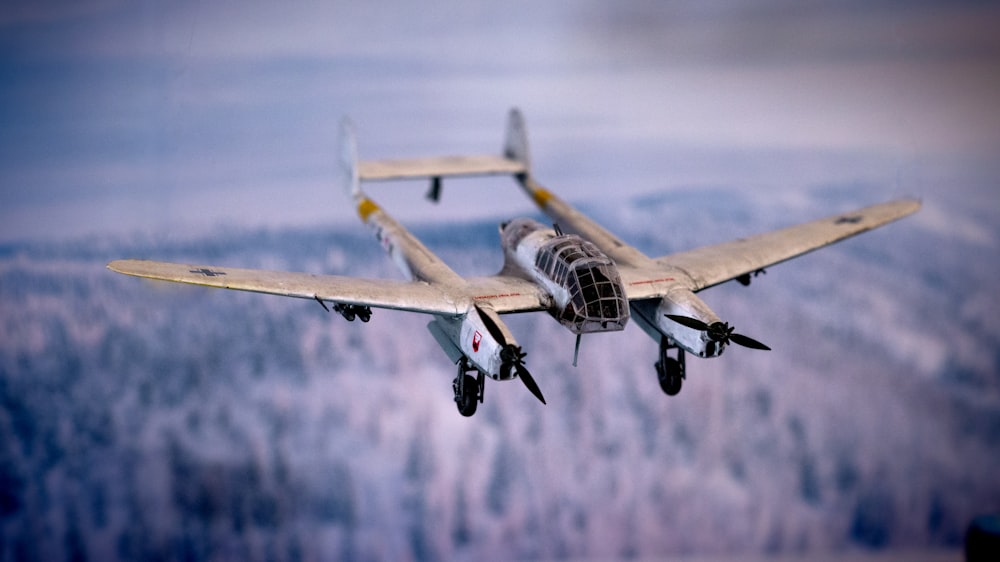 a fighter jet flying through the air over a forest