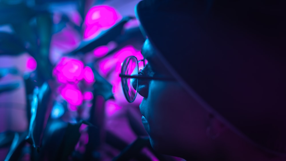 a person with glasses looking at a bunch of plants