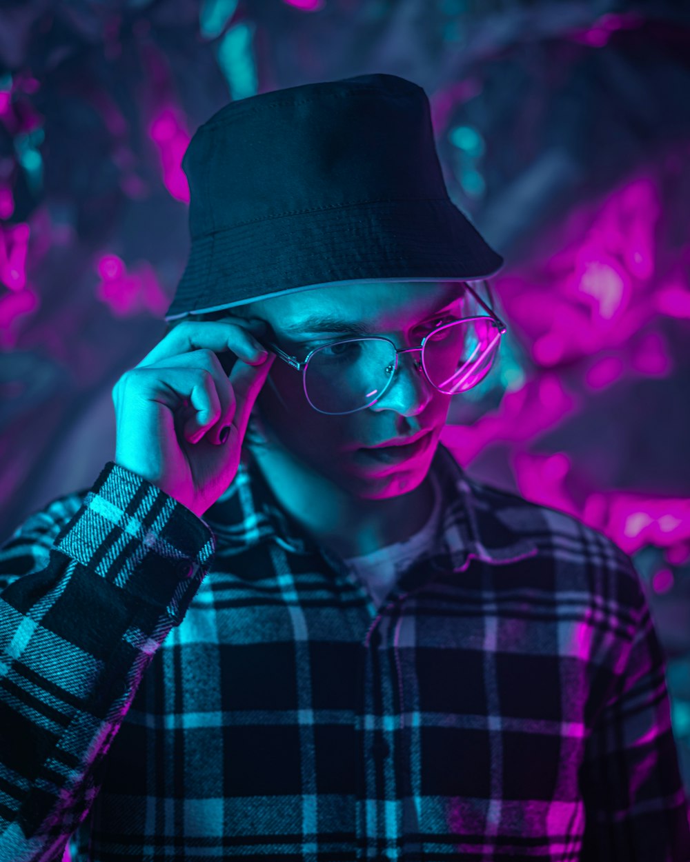 a man wearing a hat and glasses talking on a cell phone