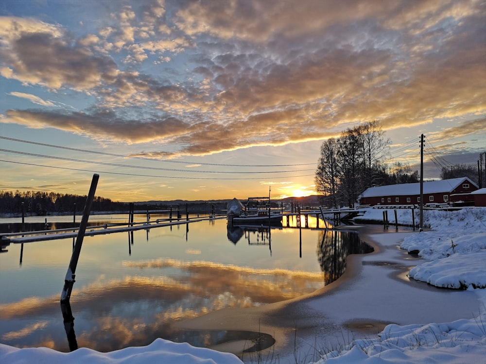 a body of water surrounded by snow covered ground