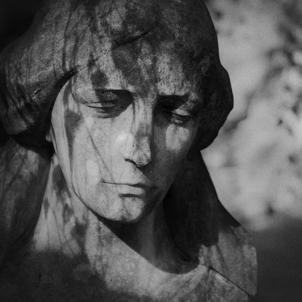 a black and white photo of a statue of a woman