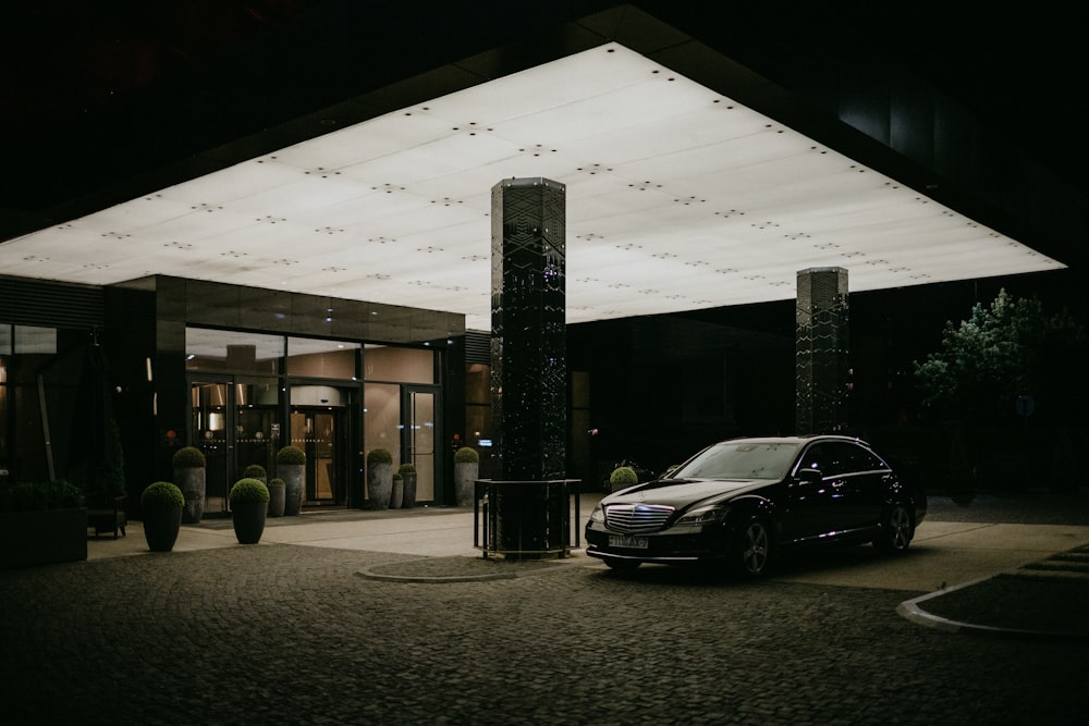 a car parked in front of a building at night