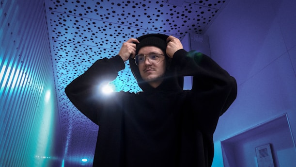 a man in a black outfit is holding his head