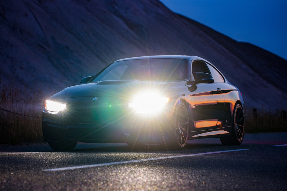 a car driving down the road with its headlights on