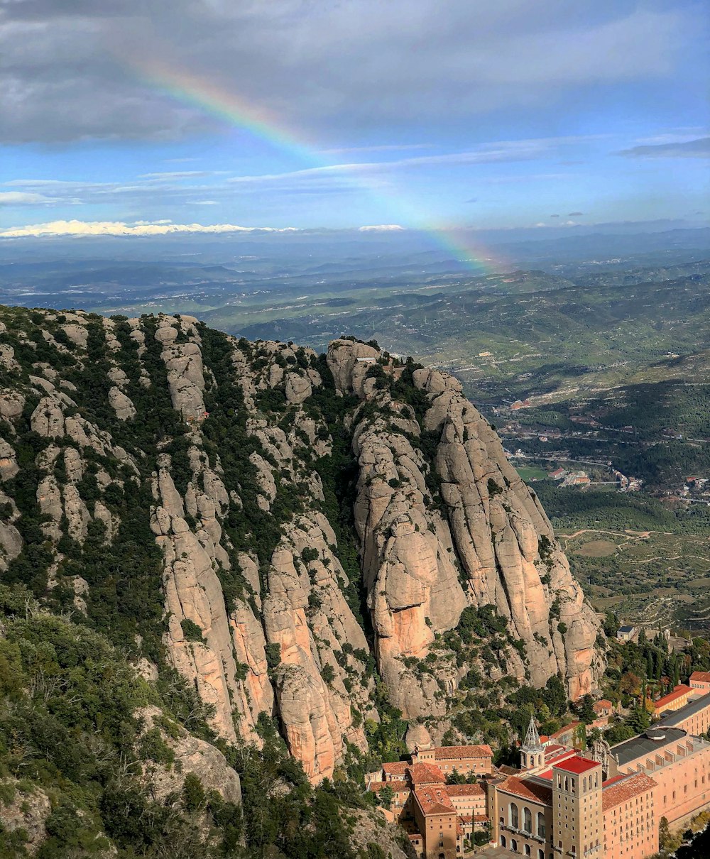 a rainbow shines in the sky over a mountain