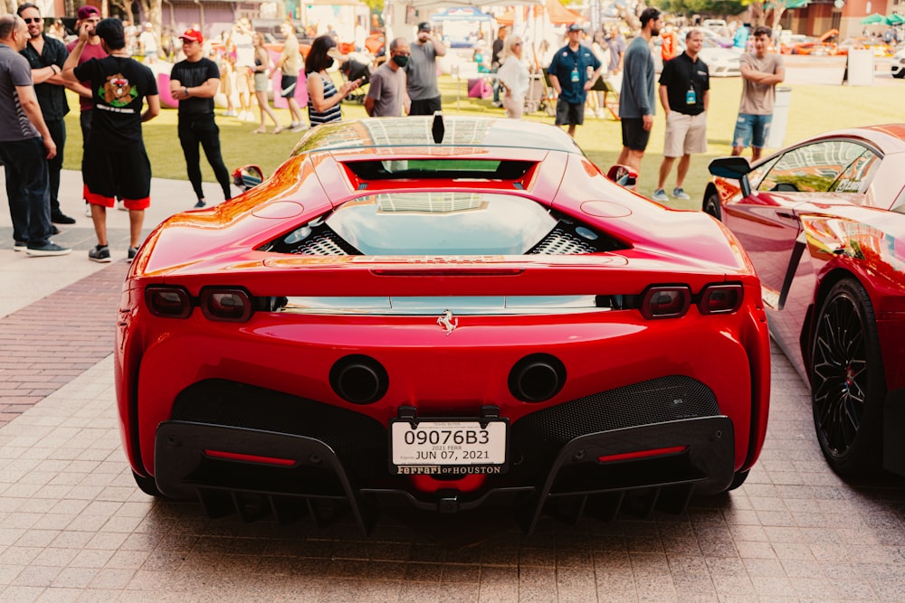 a red sports car parked in front of a crowd of people