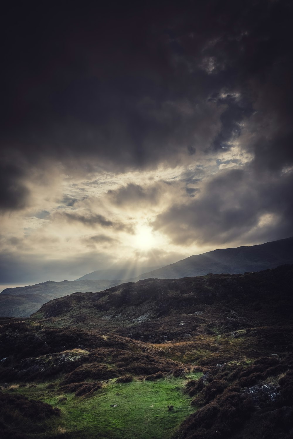 the sun is shining through the clouds over the mountains