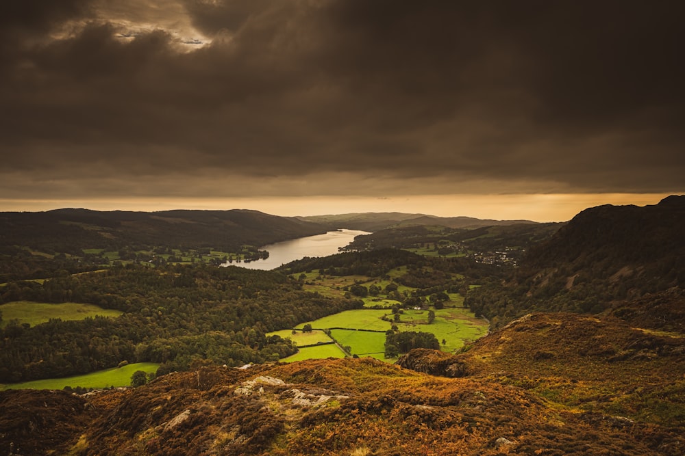 a view of a valley with a lake in the distance