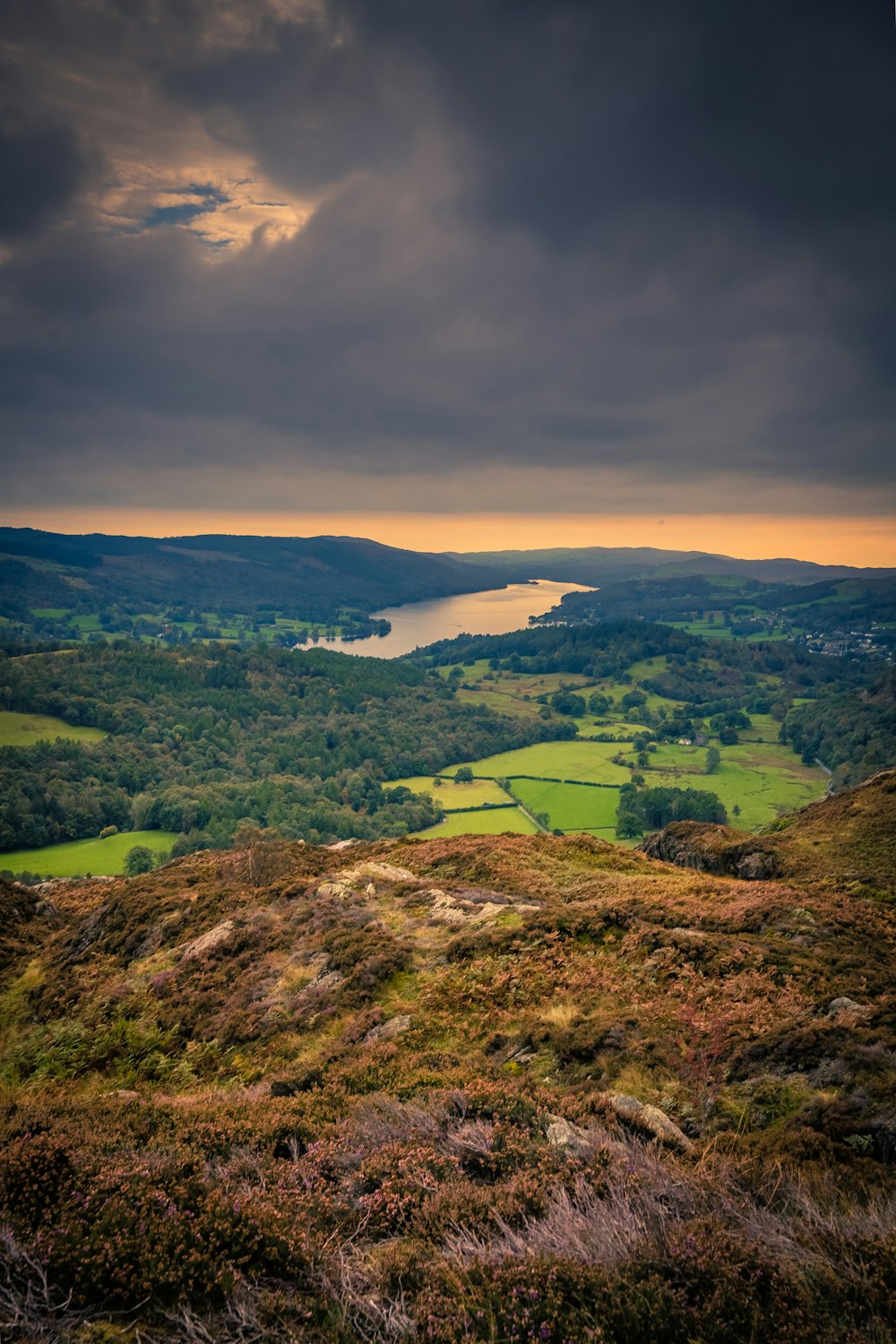 a view of a valley with a lake in the distance