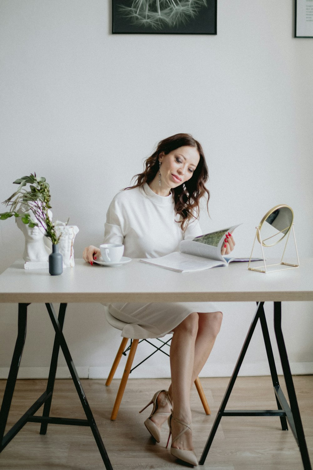 a woman sitting at a table reading a book