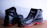A pair of black leather shoes with a rugged design and distinct red soles placed against a light background. They appear sturdy and suitable for outdoor or work use.
